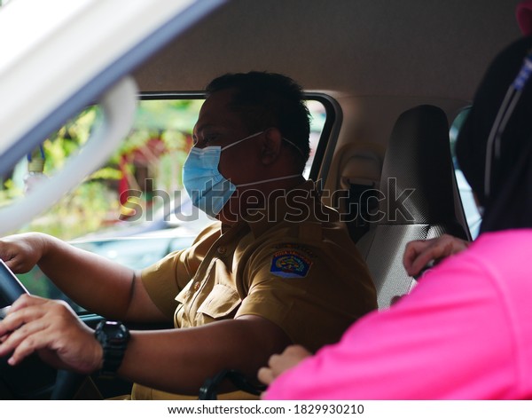 Tarakan/Indonesia-Okt 08,2020: An\
Indonesian civil servant man is driving a car at an office\
event.