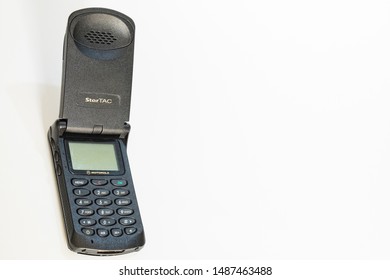 Taranto, Italy - 24 August 2019: Historic Mobile Gsm Motorola Startac Photographed On A White Background At The Side Of The Frame, Horizontal Image.