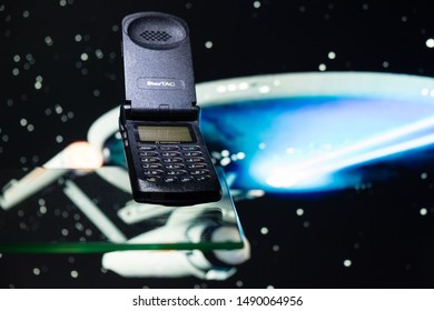 Taranto, Italy - August 24, 2019: Historic GSM Motorola Startac Mobile Phone Photographed On A Glass Plane With A Spaceship In The Background.