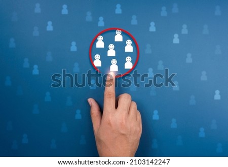 Target audience concept. Chosen group, people, white human icons in red circle pointing with hand on blue background. Human resources, customer segment, consumer marketing, and team building concepts.