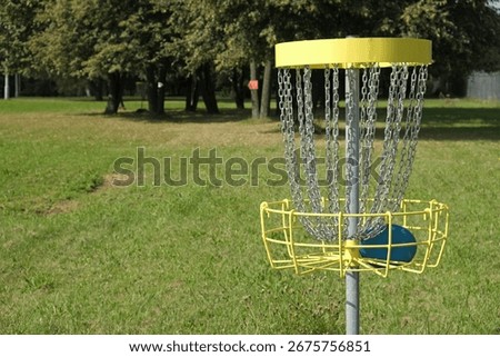 Target or basket equipped with chains to catch the disc. Disc golf area in city park. Outdoor interesting game. City leisure activity.