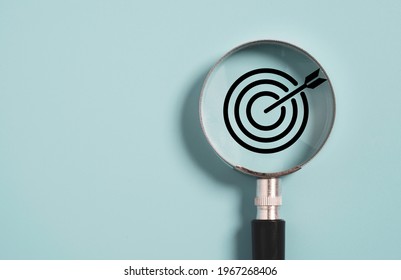 Target board inside of magnifier glass for focus business objective on blue background and copy space. - Shutterstock ID 1967268406
