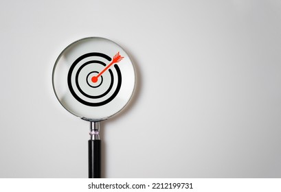 Target board inside of magnifier glass for focus business objective on white background and copy space. - Shutterstock ID 2212199731