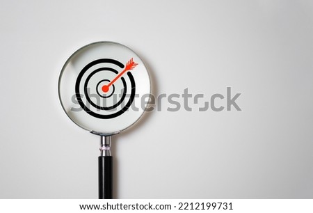 Target board inside of magnifier glass for focus business objective on white background and copy space.