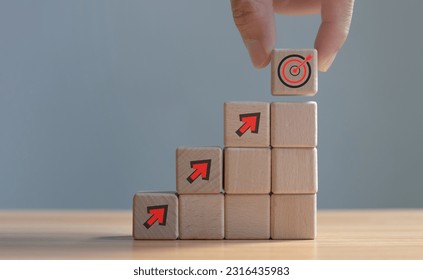 Target concept, objective, virtual target board and rising arrows screen printed on wooden cubes. set goals for business success - Shutterstock ID 2316435983