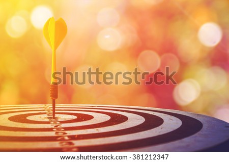target dart with arrow over blurred bokeh background ,metaphor to target marketing concept.