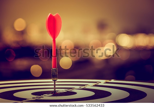 target dart with arrow\
over blurred bokeh background ,metaphor to target marketing or\
target arrow concept.