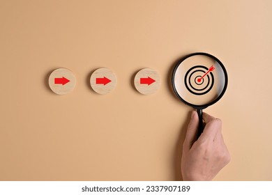 Target goal and arrow icons with magnifying glass on wooden blocks for business strategy planning management, Progress of business financial investment, Business process and workflow development - Powered by Shutterstock