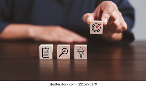 Target or goal with strategy plan-success business revenue concept. Symbols of arrows-diagrams businesses are present on wood cube. objective management, achievement startup, growth marketing idea. - Shutterstock ID 2215993179