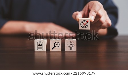 Target or goal with strategy plan-success business revenue concept. Symbols of arrows-diagrams businesses are present on wood cube. objective management, achievement startup, growth marketing idea.