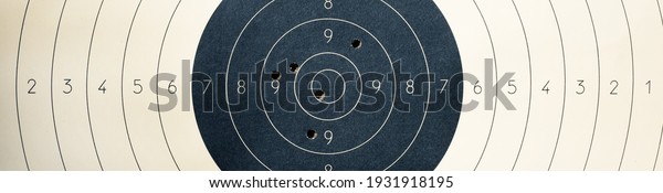 Target with numbers for shooting\
at a shooting range. A round target with a marked bull\'s-eye for\
shooting practice on the shooting range. Target with bullet\
holes