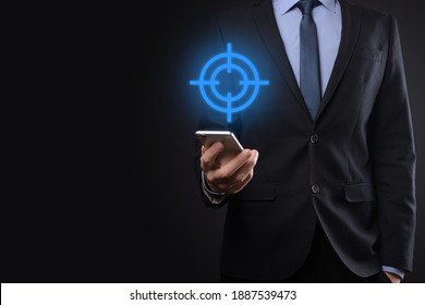 Targeting concept with businessman hand holding target icon dartboard sketch on chalkboard. Objective target and investment goal concept - Shutterstock ID 1887539473