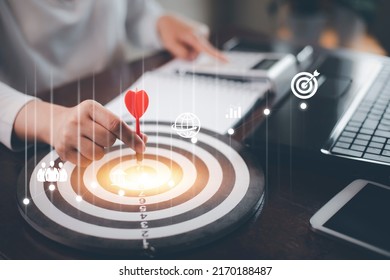 Targeting with marketing business concept, Businesswoman hand holding red dart to the virtual target dartboard, Executive marketing, investment goal and target for business investment concept, 