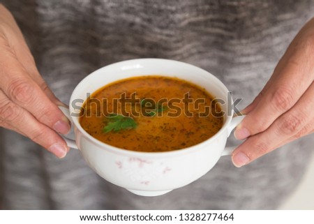 the Tarhana soup in the bowl that the woman hold it for kitchen and food concept. 