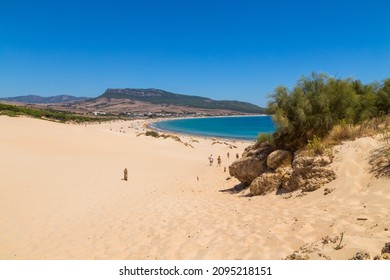 Tarifa, Spain - August 15, 2021. Tourists walking to The Playa de Bolonia Beach, a unspoiled white sand beach of Tarifa, Cadiz. Andalusia, Spain.