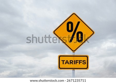 Tariffs. Sanctions and tariff increases, creative idea. Yellow tariffs sign on gray cloudy sky, concept. 
