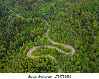 Tarmac Road Seen From Above. Aerial View Of An Extreme Winding Road Through Middle Of The Forest