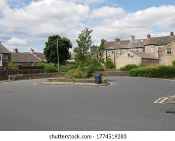 Tarmac Surfaced Bus Turning Circle With Central Planted Island Blue Waste Bin With Trees And Houses In The Background Huddersfield Yorkshire England 12/07/2020 By Roy Hinchliffe