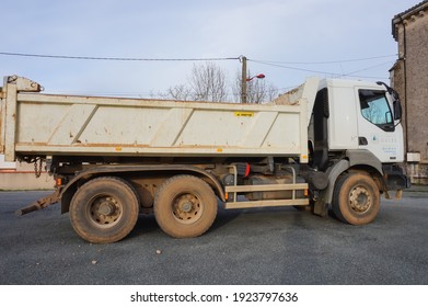 Tarn, France - Feb. 2021 - Side View Of A White, Six-wheeled  Tipper Truck, Made In France By The Manufacturer Renault, In A Parking Lot ; The Dumper And The Wheel Tyres Have Traces Of Dried Mud