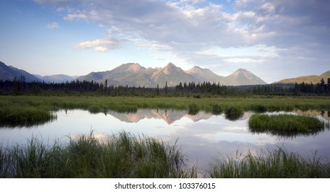 A tarn reflects beauty along the Chugach Mountains and Hwy 1 in Alaska