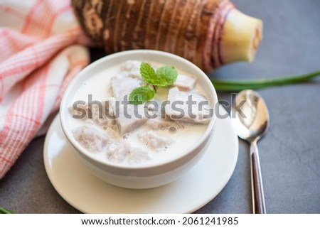 Taro food with dessert taro boiled with sugar and coconut milk on bowl and fresh raw organic taro root ready to cook, Asian Thai food