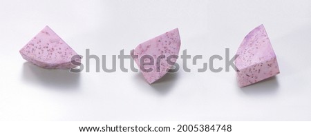 Taro pieces cut isolated in white background. Closeup of purple sweet potato vegetable ingredients for food styling decoration