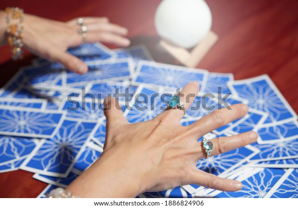 Tarot card reading on cloth for fate or\
fortune telling through design card. Gypsy paranormal in spell of\
card reading. Gypsy fortune telling blue\
card