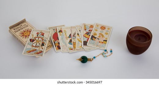 Tarot cards for a fortune -teller and pendulum isolated on white - Powered by Shutterstock