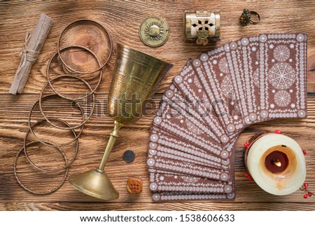 Tarot cards and golden goblet on brown table of fortune teller. Divination. Future reading concept.