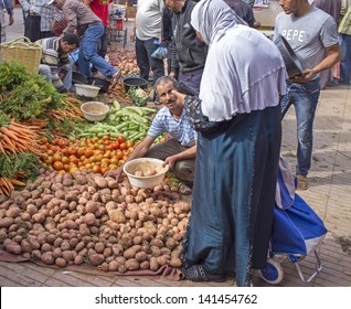 TAROUDANT, MOROCCO - OCTOBER 24: Woman buying fresh vegetables from the market on October 24, 2012 in the ancient town of Taroudant in Morocco.
