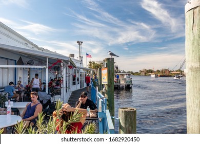 Tarpon Springs, Florida / USA - 1/18/2019:  Vacation Tourist Eating And Drinking While A Large Catamaran Pontoon Sightseeing Party Boat Embarks The Dock Port Side Of The Gulf Coast On A Day Cruise