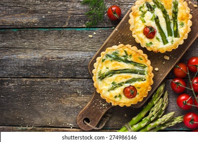 tart with asparagus and cherry tomatoes  on rustic background, top view