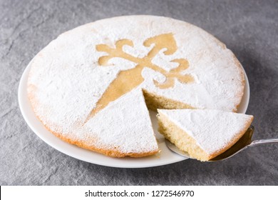 Tarta de Santiago. Traditional almond cake slice from Santiago in Spain on gray background