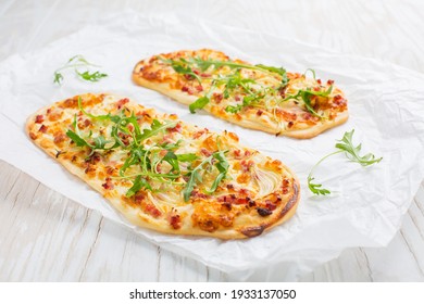 Tarte Flambee - flat bread (Flammkuchen) with bacon, onion, champignon and cheese on white background