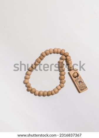 Tasbih is a prayer beads or islamic rosary is a medium used by muslims to recite (zikr) when finished praying (shalah). This is made of wood material and has 33 seeds isolated on white background.