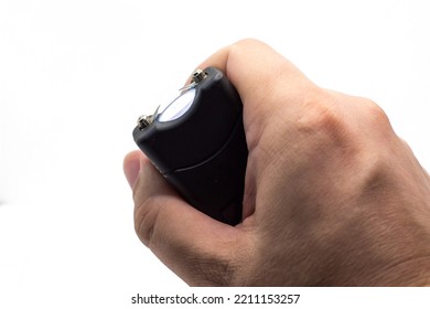 Taser In A Man Hand Close-up, Isolated On A White Background.