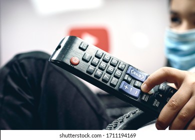 Tashkent, Uzbekistan - 26 March 2020: A Little Boy Watching Youtube During Coronavirus Self-quarantine. A Kid In Protective Medical Gloves Holds Remote Control And Watches TV