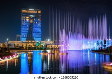 Tashkent, Uzbekistan - 30 October, 2019: beautiful dancing fountain illuminated at night with reflection in pond in new Tashkent City Park