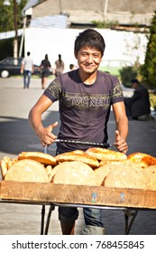 TASHKENT, UZBEKISTAN - October, 2014: Uzbek man selling uzbek bread at Chorsu bazar in Tashkent, one of the oldest markets in the country, Uzbekistan