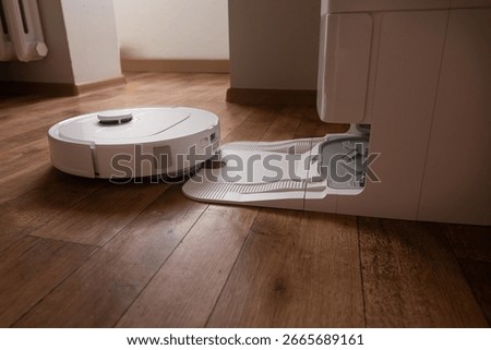 Task done the robot vacuum returns smoothly to its home base to recharge batteries and empty the dustbin without