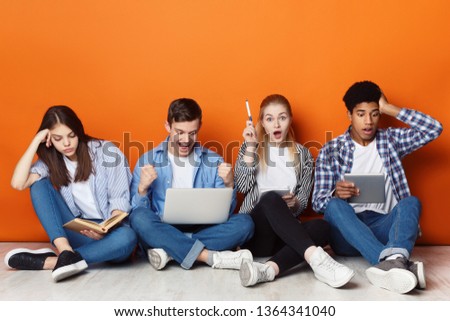 Task and learning concept. Students preparing for exams over orange studio background