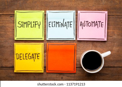 Task management concept: simplify, eliminate, automate, delegate. Handwriting on sticky notes against rustic wood board with a cup of coffee