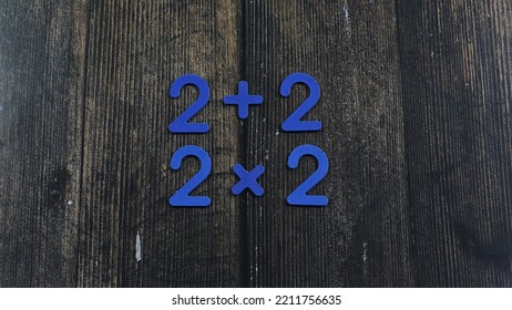 Task In Mathematics. Mathematics Problem For Children. Simple Algebra Examples Using Numbers And Signs From Plastic Numbers On A Wooden Background.