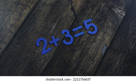 Task In Mathematics. Mathematics Problem For Children. Simple Algebra Examples Using Numbers And Signs From Plastic Numbers On A Wooden Background.