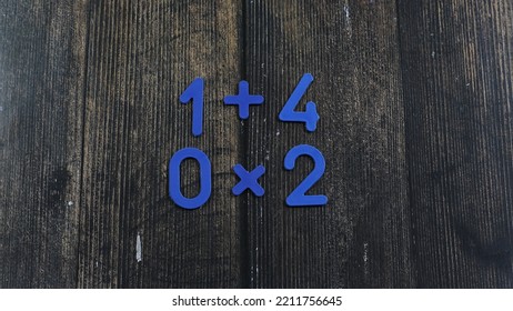 Task In Mathematics. Mathematics Problem For Children. Simple Algebra Examples Using Numbers And Signs From Plastic Numbers On A Wooden Background.