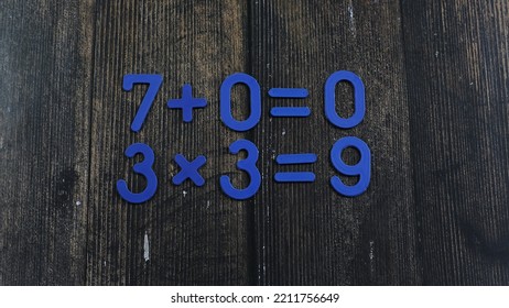 Task In Mathematics. Mathematics Problem For Children. Simple Algebra Examples Using Numbers And Signs From Plastic Numbers On A Wooden Background.