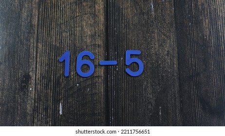 Task In Mathematics. Mathematics Problem For Children. Simple Algebra Examples Using Numbers And Signs From Plastic Numbers On A Wooden Background.