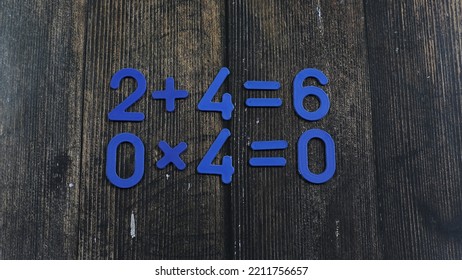 Task In Mathematics. Mathematics Problem For Children. Simple Algebra Examples Using Numbers And Signs From Plastic Numbers On A Wooden Background.