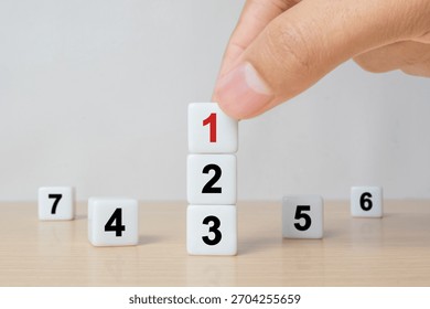 Task priority and management concept, The order of priority in any activity, Set work priority, arrange to do list. Hand arranging dice with number first, second, third, four, five, six, seven.