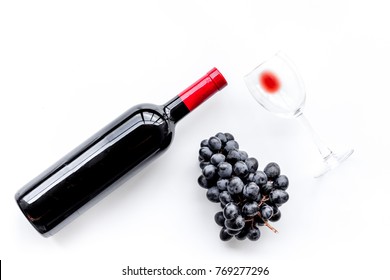 Taste Red Wine. Bottle Of Red Wine, Glass And Black Grape On White Background Top View